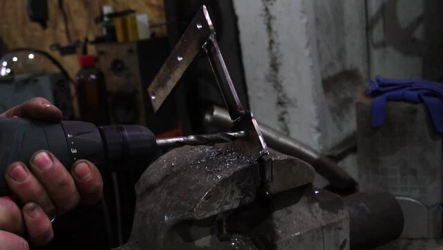 a locksmith performs metal drilling, making custom parts for a car	