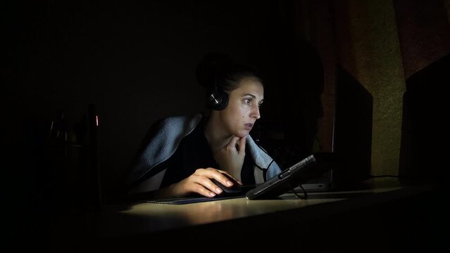 online work at home in the dark without light at the laptop with headphones