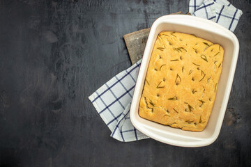 focaccia with rosemary on a dark background. banner, menu, recipe place for text, top view