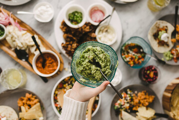 Cropped hand of woman holding bowl of chutney at dining table