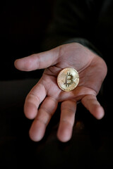 Hand holding and showing a golden Bitcoin, - 546641837