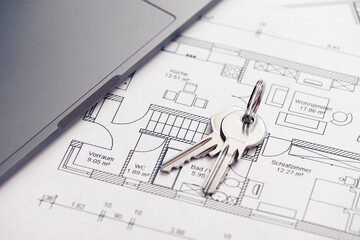 key and architectural blueprint map or drawing of house or future home at landlord real estate agent