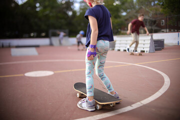 girl and skateboard at skatepark getting ready to ride board