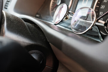 Glasses on the dashboard of a car. Accessory for drivers with vision problems. Road safety concept.