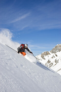 A young man skis untracked powder off-piste at St. Anton am Arlberg, Austria.