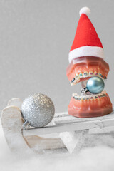 
Lustiger zahnärztlicher Weihnachtshintergrund mit Platzhalter. Zahnmodell mit festsitzender...
