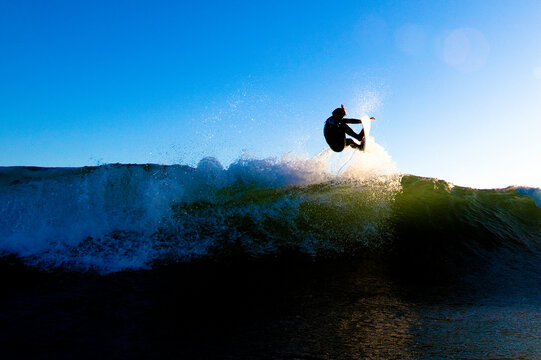 A skilled male surfer launches an air.