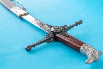 Cossack sword in a scabbard, close-up on a blue background