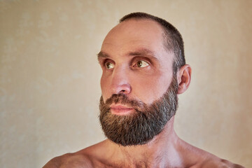 Fototapeta premium Portrait of a thoughtful handsome naked bearded man looking away