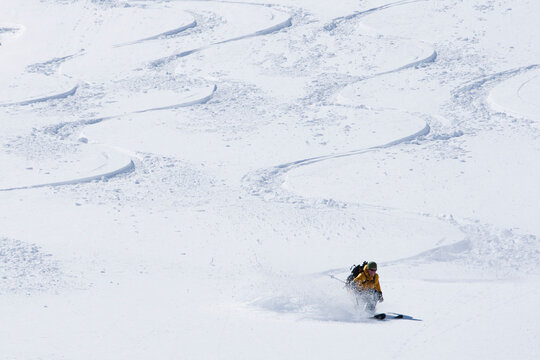 One man skiing a new line between other skiers' tracks.
