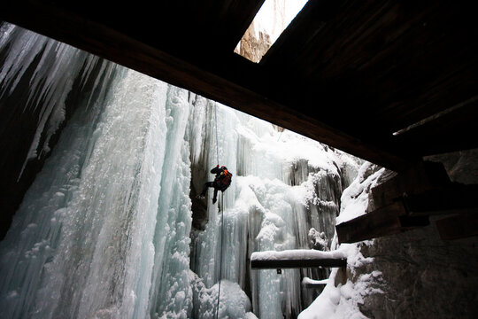 A Man Rappelling From An Icefall