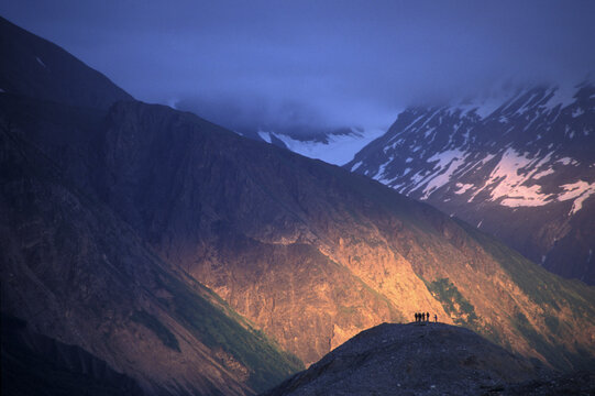 Hikers peer into depths of canyon during river expedition, British Columbia.