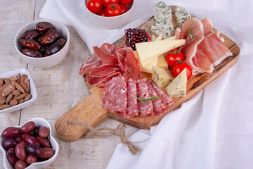 Italian antipasti wine snacks set. Cheese variety, Mediterranean olives, pickles, Prosciutto di Parma, pepper and salami. Charcuterie board.	