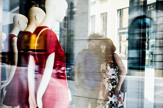 Couple in the city looking at clothing store window