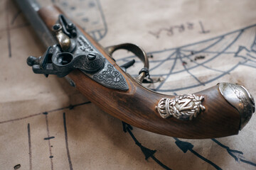Vintage pirate pistol musket on a treasure map. The text on the map is earth.