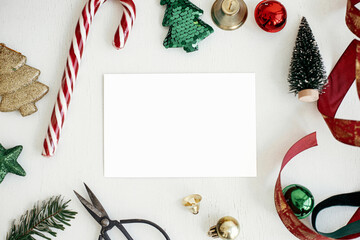 Christmas card flat lay. Empty greeting card mock up with christmas decorations on rustic table © sonyachny