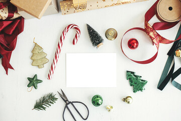 Christmas card flat lay. Empty greeting card mockup with christmas decorations on white rustic table