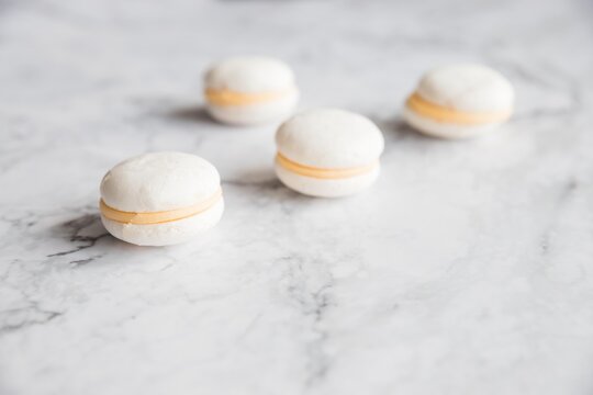 Cake macaron or macaroon on marble background from above, white almond cookies, pastel colors, vintage card, top view.advertisement, copy space