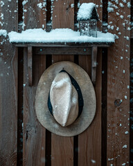 hat on fence with snow