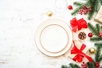 Christmas food, christmas table setting with white plate, golden cutlery and christmas decorations on white wooden background. Top view with copy space. - obrazy, fototapety, plakaty