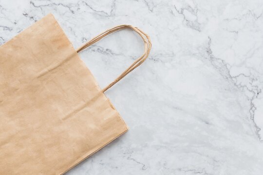 blank craft paper bag for takeaway isolated on marble background. Packaging template mock up. Delivery service concept. Copy space. Advertising area.kraft paper bag.