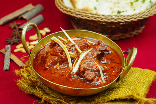 Achari chicken korma rogan gosht with bread served in karahi isolated on table top view of indian, pakistani and punjabi spicy food