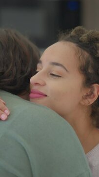 Lesbian couple hugging at home
