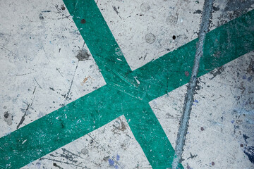Fototapeta na wymiar Grungy and dirty green cross painted on a white surface.
