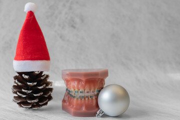 
Lustiger zahnärztlicher Weihnachtshintergrund mit Platzhalter. Zahnmodell mit festsitzender...