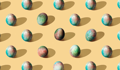 Pattern of easter eggs on yellow pastel background