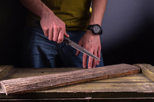 The man holds a sharp knife in his hand. Hit with a sharp knife. Big knife in hand. Attack with a knife.