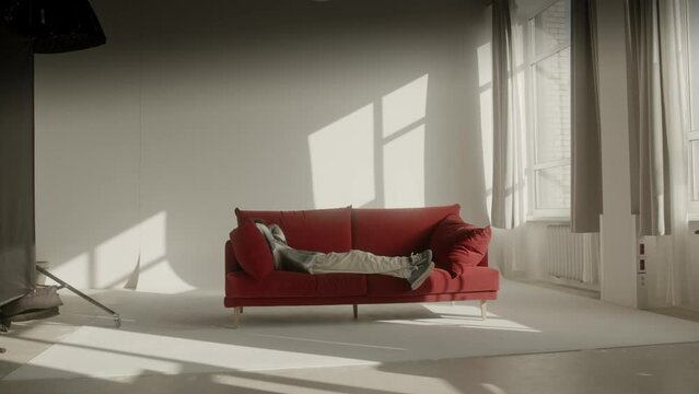 a young boy relaxing on a big red sofa