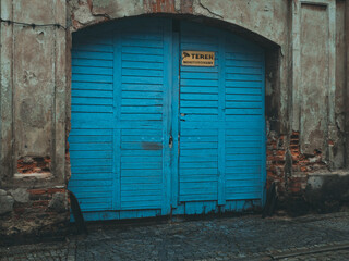 blue gate doors in ruined building