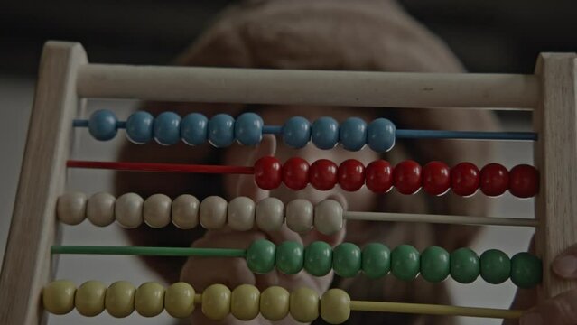Young asian girl using an old wooden abacus and calculator doing mathematics
