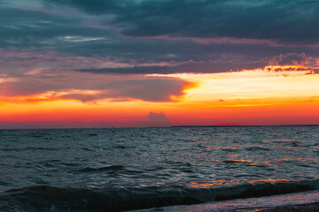 Amazing Black sea red sunset. Dark blue Clouds and water landscape background. Drama juicy orange sky. Golden blue hour at the ocean romantic evening. Tropical island summer paradise. Wild rest camp