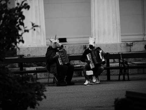 White and black shot of street musicians wearing horse and unicorn masks