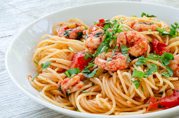 Primo piano di deliziosi spaghetti con gamberi, pomodoro e prezzemolo, pasta italiana