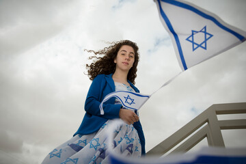 Beautiful jewish dark hair girl or woman with Israel jewish symbols dressed in the colors of the...