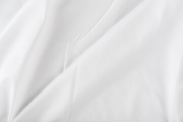 Plakat White wrinkled fabric. White fabric with large folds top view. For overlay texture or design.