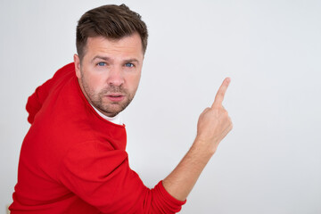 Fototapeta premium Serious man pointing finger up showing logo promo aside, pay attention here