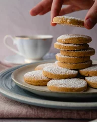 Keuken spatwand met foto Vertical shot of appetizing fresh vanilla biscuits with sugar powder sprinkled on top © Adam Bartoszewicz/Wirestock Creators