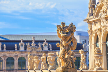 Fototapeta na wymiar Cityscape - view of a sculptures on the balustrade against the backdrop of the architecture Zwinger Palace complex in Dresden, Germany