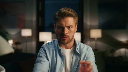 Serious guy playing video game at flat closeup. Energetic man gesturing hands