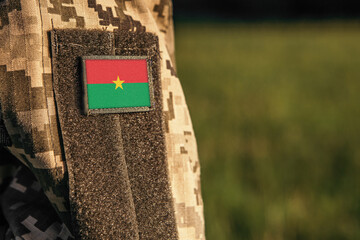 Close up millitary woman or man shoulder arm sleeve with Burkina Faso flag patch. Burkina Faso...