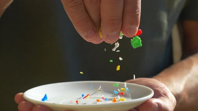 Micro plastics falling close up, slow motion. Microplastic pollution concept, garbage and trash, ecological problems. Global warming and climate change