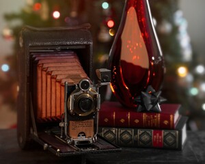 Holiday Antique Camera w/ Black Bow Set on a Rustic Holiday Background with warm lights