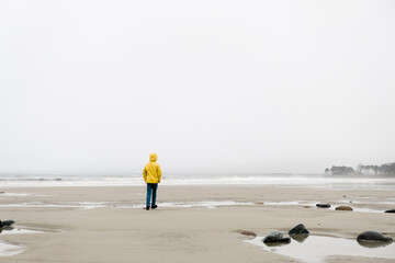 f boy with yellow coat on the seaside on Maine 