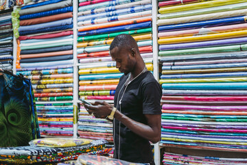 Black man using smartphone in store