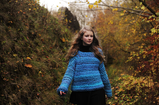 A girl in a blue knitted jumper hiking in winter