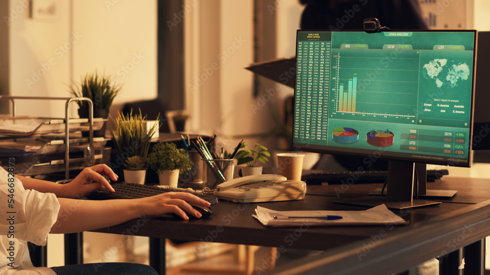 Poster Female employee looking at financial diagrams on monitor, analyzing charts notes and doing paperwork. Working on presentation planning with data, creating startup company report.